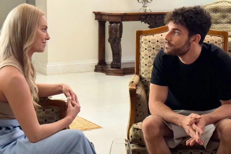 Abby and Theo having a heartfelt conversation in an elegant room with antique furniture.