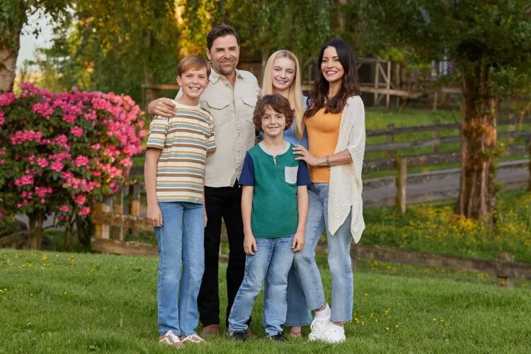 A family of five standing together outdoors, smiling for a group photo. From Hallmark's "Big Sky River: The Bridal Path" 