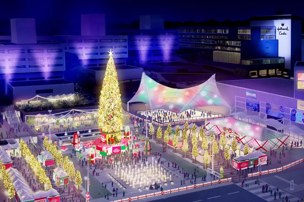 Artist's rendering of the Hallmark Christmas Experience at Crown Center in Kansas City. The scene features a large, illuminated Christmas tree at the center, surrounded by festive market stalls, an ice skating rink, and beautifully lit trees. People are gathered, enjoying the holiday activities and decorations at night.