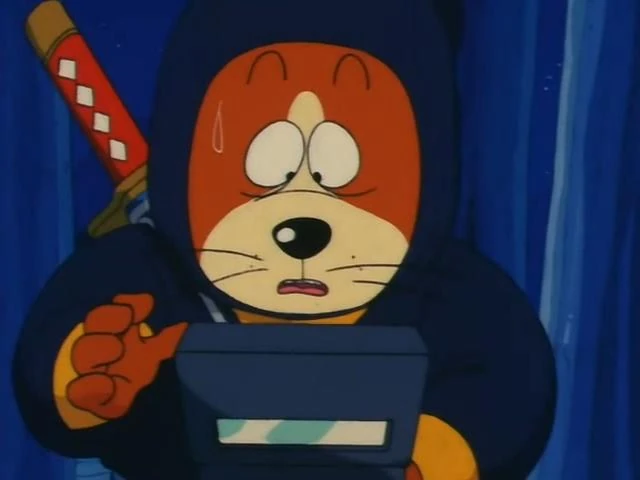 A scene from Dragon Ball featuring a dog character disguised as a ninja. He is wearing a dark hooded outfit, holding a rectangular device with a focused but nervous expression. A sweat drop on Puar's face suggests tension or concern. A katana with a red and white checkered sheath is strapped to their back. The background is dark blue, emphasizing the stealthy and mysterious tone of the moment. Classic Dragon Ball comedic and adventurous vibes shine through.