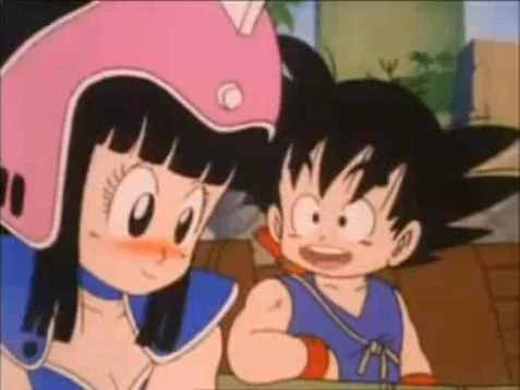 A sweet moment between Goku and Chi-Chi from Dragon Ball, with Chi-Chi blushing and Goku flashing his innocent smile.