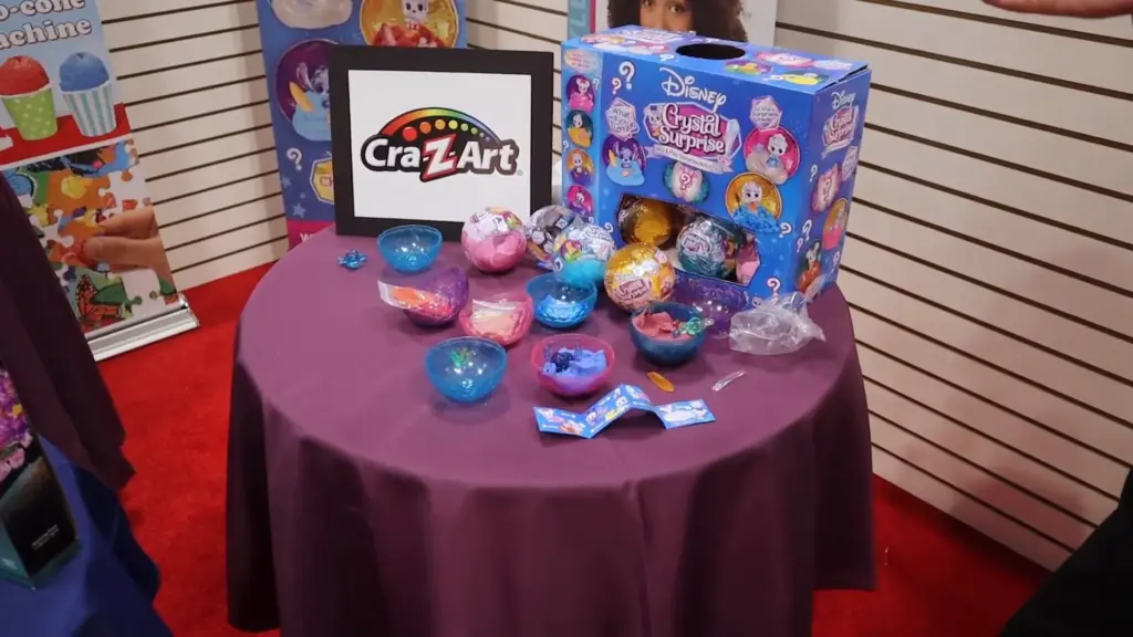Full table setup of Disney Crystal Surprise toys from Cra-Z-Art at Toy Fair NY 2025, showing multiple collectible spheres, accessories, and packaging.