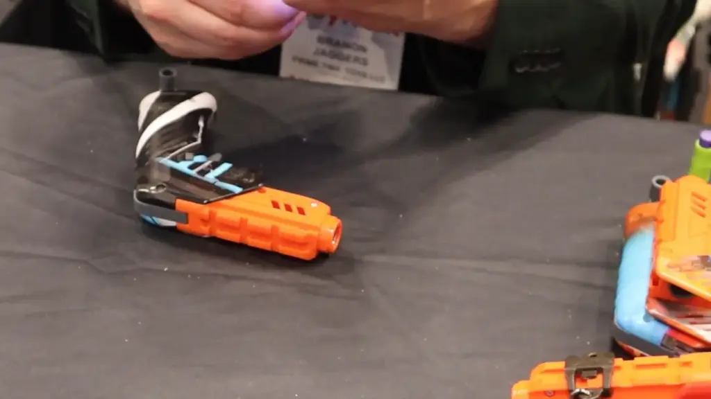 Finished Dart Zone Solo blaster after assembly at Toy Fair NY 2025, featuring black, blue, and orange detailing on the completed design.