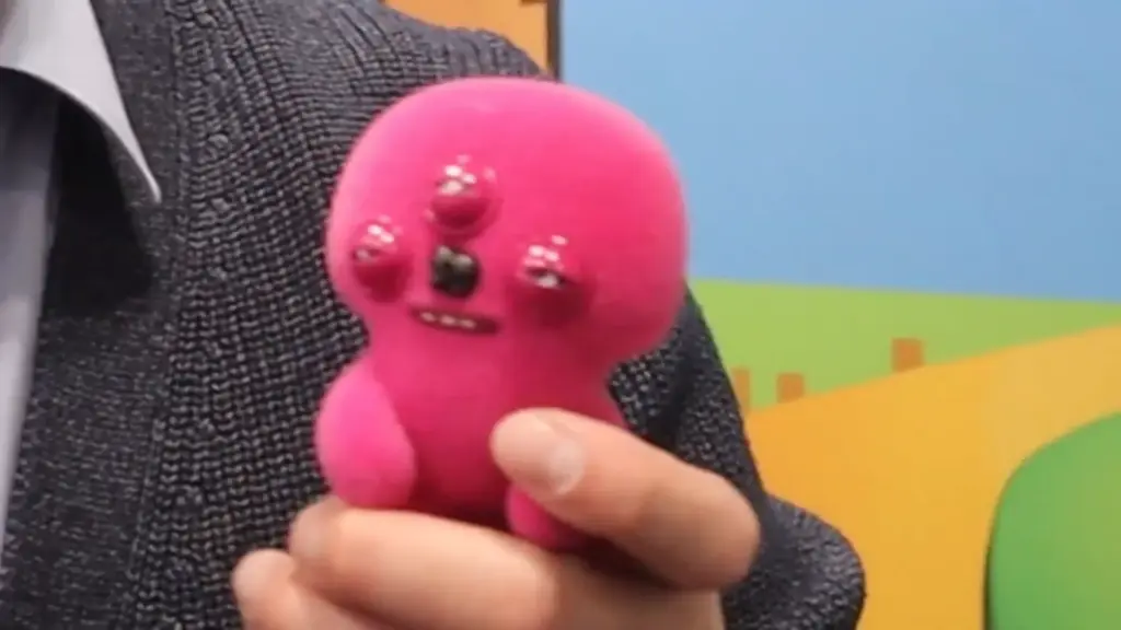A pink Fuggler collectible figure with multiple eyes and a mischievous grin showcased at the Toy Fair NY 2025 PMI Kids World booth, representing the brand’s quirky and humorous design style.