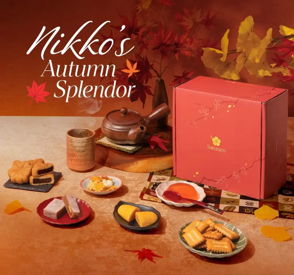 Sakuraco Nikko Autumn Splendor Box featuring traditional Japanese sweets, teas, and autumn-themed snacks arranged beside a red gift box with fall leaves and warm seasonal decor.