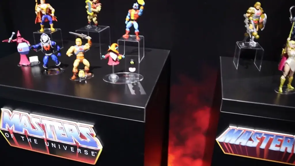 Masters of the Universe action figures from the Toy Fair NY 2025 Mattel showcase, including He-Man, Orko, and She-Ra displayed on branded stands with bold lighting.