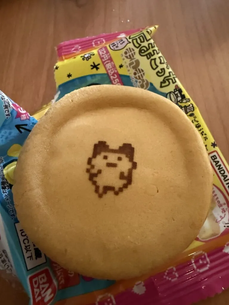 A Tamagotchi Manmaruyaki dessert featuring a cute Tamagotchi character design printed on top of the fluffy pancake-like treat.