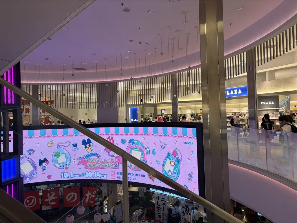Bright LED screen at Shinsaibashi PARCO mall advertising the Tamagotchi pop-up store event with cute characters and event dates.