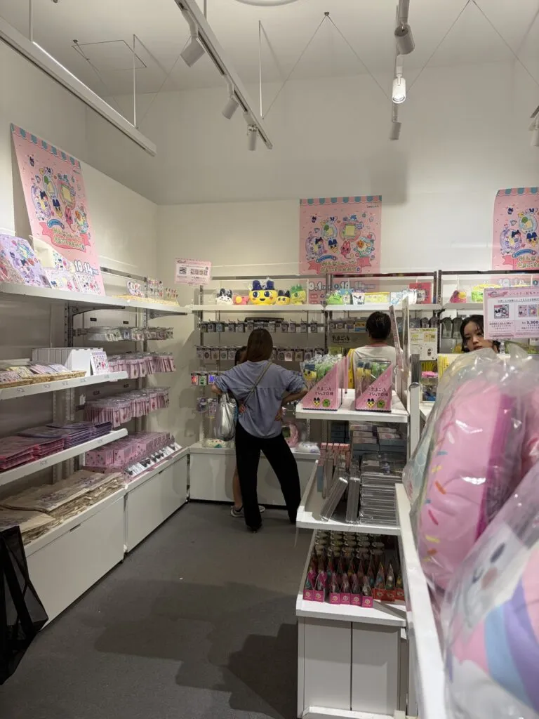 Shoppers browsing shelves full of colorful Tamagotchi merchandise inside the Shinsaibashi PARCO pop-up store.