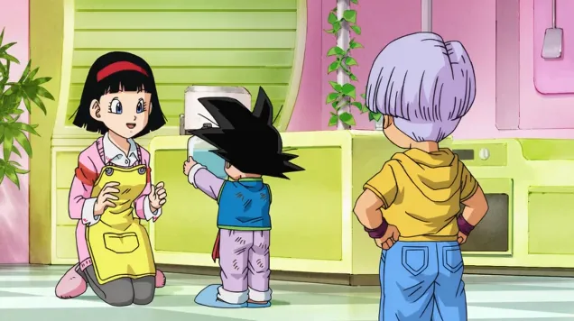 Videl kneeling and smiling in the kitchen as young Goku proudly holds up a glass bottle, with Trunks standing nearby watching, surrounded by bright green cabinets and a warm, colorful room.