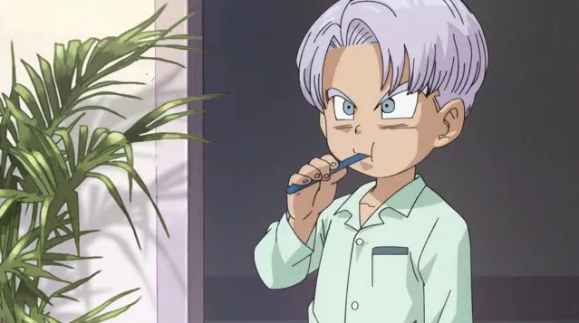 Trunks brushing his teeth in mint green pajamas, looking serious and focused, with a houseplant visible beside him in the background.