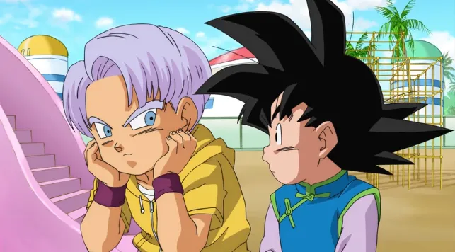 Trunks sitting with his cheeks resting in his hands, looking annoyed and bored, while Goten stands beside him watching with curiosity at a playground area in the background.