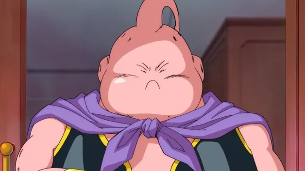 Majin Buu puffing up his cheeks with a determined, almost pouty expression, wearing his purple cape and black outfit, standing indoors as if bracing himself for something important or stubbornly holding his ground.