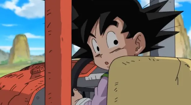 Goku sitting on a farm vehicle seat, turning his head with a surprised expression while holding the steering wheel, with part of the tractor and farmland visible around him.
